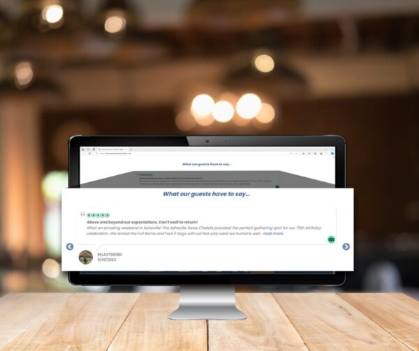 Computer screen displaying a 5-star guest review on a hospitality website, shown in a cozy lodge environment with warm lighting in the background.