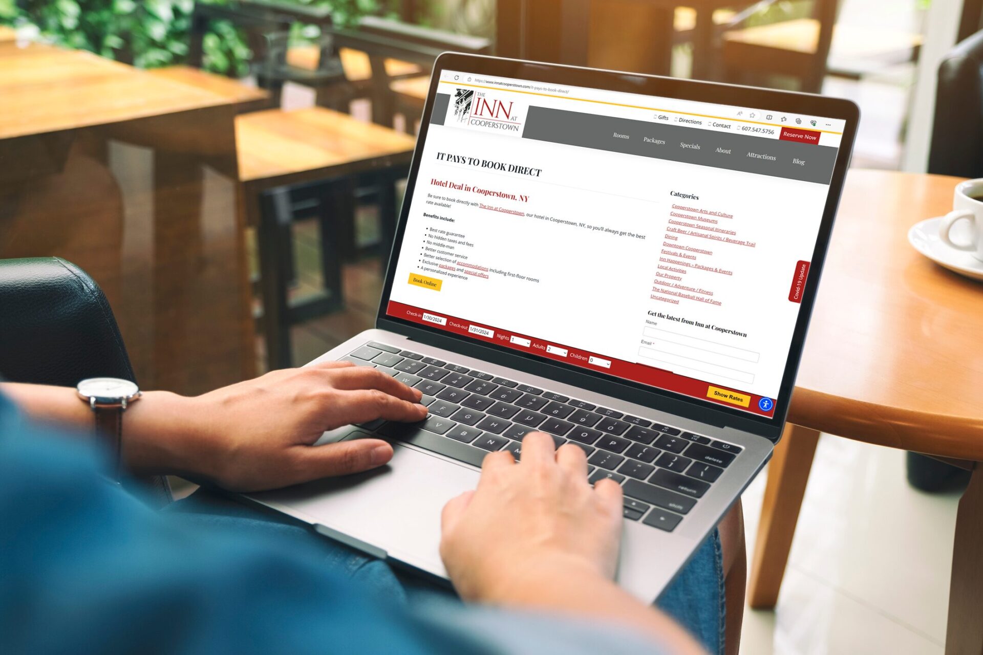 Person viewing a hotel’s ‘Book Direct’ benefits page on a laptop, demonstrating how properties showcase direct booking advantages online.