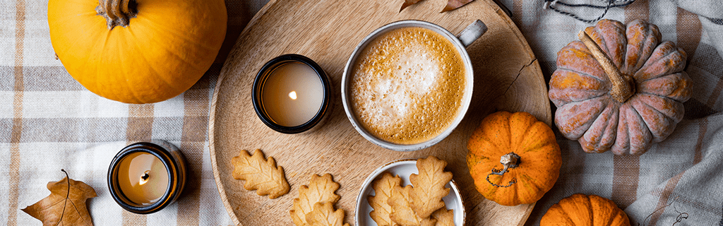 Cozy hotel lobby decorated for Thanksgiving with pumpkins, rustic wreaths, and warm lighting.
