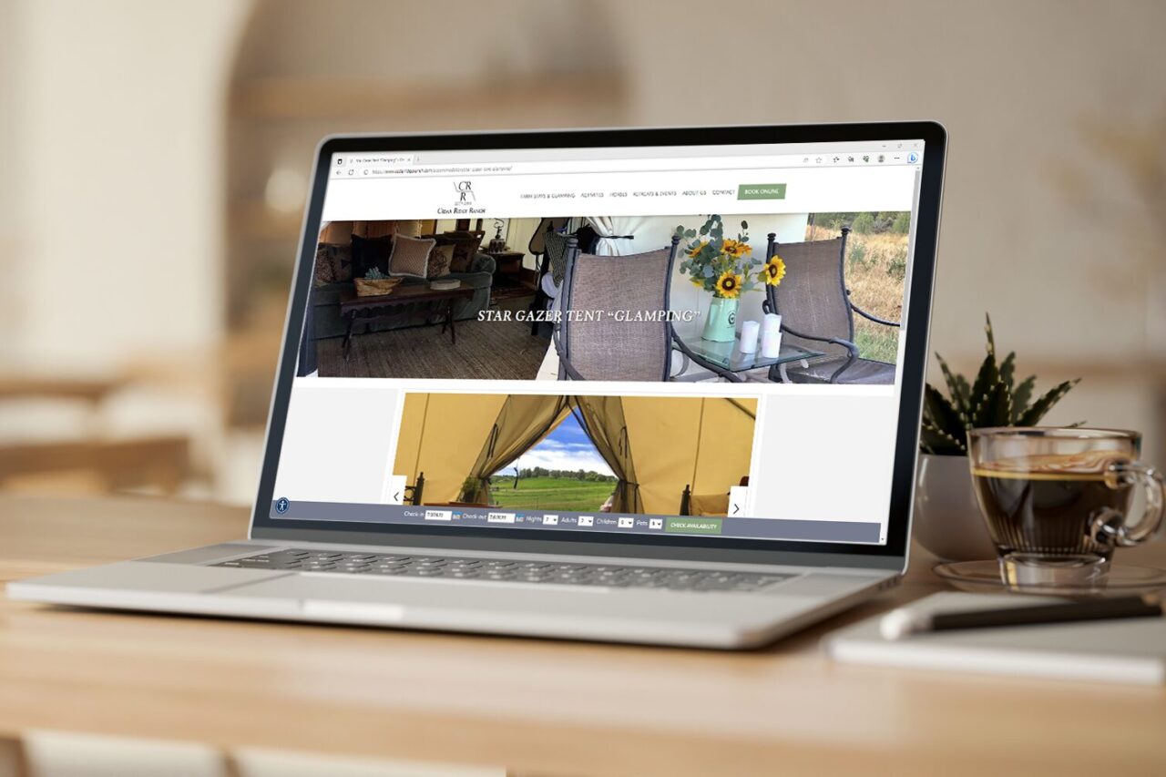 Laptop displaying a glamping lodging website.