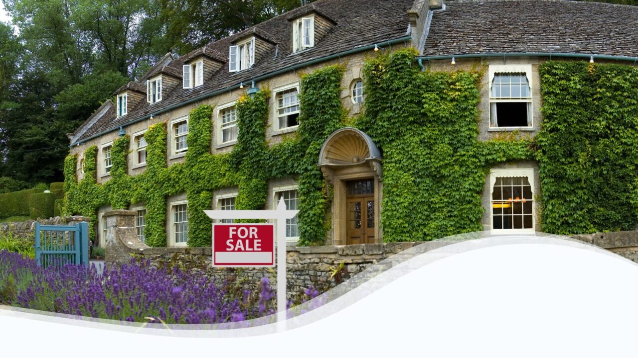 Image of a rustic inn with a "For Sale" sign in front.